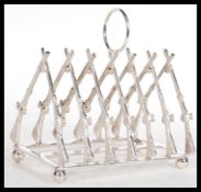 A silver plated toast rack of hunting interest with the rack being in the form of crossed rifles.