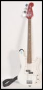 A vintage unknown-make Fender Precision Base style electric bass guitar. White body, with red