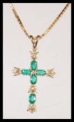 A 9ct gold and emerald cross pendant set to a 9ct gold box linked necklace chain. emeralds approx