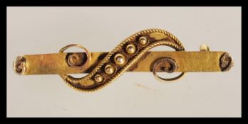 A 14ct gold 19th Century Victorian bar brooch having scrolled decoration to the front. tests as 14ct