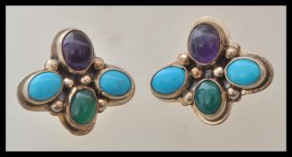 A pair of Art Deco style sterling silver earrings being set with turquoise and amethyst cabochons.