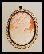 A hallmarked 9ct gold carved shell cameo brooch / pendant having central carved cameo portrait of