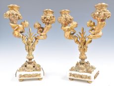 A PAIR OF 19TH CENTURY BRONZE GILT CHERUB TWIN SCONCE CANDELABRAS.