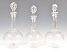 A SET OF THREE 19TH CENTURY GLASS DECANTERS AND STOPPERS