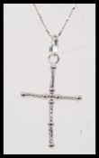 A stamped 750 white gold necklace having a crucifix pendant on a fine twisted chain. Chain