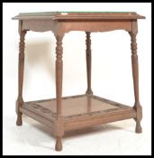 A 19th Century Victorian carved oak side table being raised on gun barrel supports with twin tiers