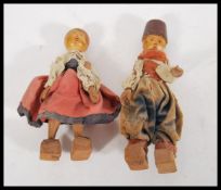 Two vintage retro wooden dolls in the form of an Austrian lady and man dressed in traditional