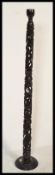 A 20th Century African tribal carved hard wood standard lamp constructed from pierced decoration