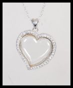 A stamped 925 silver pendant necklace having a heart shaped locket pendant set with cz's with a