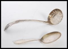 A silver hallmarked tea strainer of curved form having gadrooned decoration with a pierced bowl (