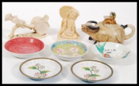 A collection of Chinese and Oriental wares to include a porcelain Yixing teapot in the form of an Ox