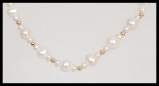 A 20th Century pearl necklace having repeating graduation design with a yellow metal pearl clasp.