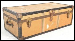 A vintage retro early 20h Century suitcase trunk being canvas and brass bound in a tan colourway.