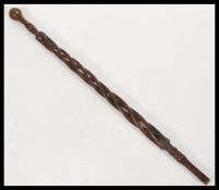 A 19th Century Victorian folk art walking stick cane having a carved twist open column with knob