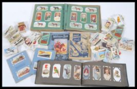 A selection of vintage cigarette cards to include two small albums and a selection of mixed