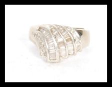 A hallmarked 18ct white gold ring set with three rows of step cut diamonds to the head. Hallmarks