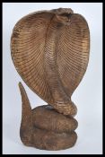 A large and impressive hand carved figurine statue in the form of a python snake modelled in an