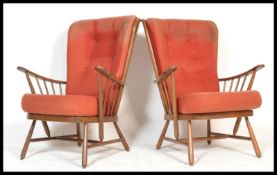 A pair of Ercol beech spindle back fireside armchair,  with upholstered cushions, raised on turned