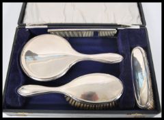 A vintage early 20th Century hallmarked silver brush set consisting of two brushes, mirror and