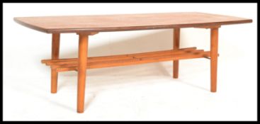 A retro vintage 20th century teak wood coffee table raised on tapering supports having rail magazine