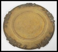 A 19th Century Chinese bronze charger plate having relief central dragon decoration with grape and