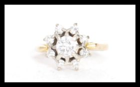 A stamped 18ct gold diamond cluster ring having a central diamond surrounded with eight smaller