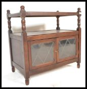A 20th Century oak side cabinet having twin doors with glazed leaded windows with a raised side