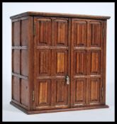 A 19th Century Victorian oak smokers cabinet in the folded linen / linen fold pattern having twin