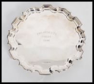 A 20h Century hallmarked silver salver tray plate of scalloped form raised on scrolled feet.