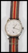 A vintage Omega mid 20th Century military watch having a round face with a white dial and luminous