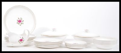 A vintage Royal Doulton dinner service in the 'Sweetheart Rose' pattern having a white round with