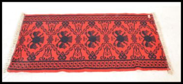 A vintage 20th Century Eastern European Russian / Albanian floor carpet rug having a red ground with