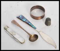 A collection of silver items to include a hallmarked napkin ring, hallmarked thimble, sterling