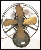 A vintage early 20th Century industrial cast metal desk top oscillating fan by TBH, raised on a