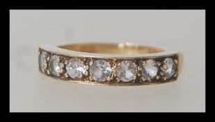 A hallmarked 9ct gold ring having seven flush set white stones. Size L.5. Weighs 3 grams.