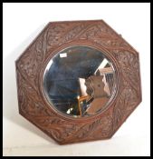 A 19th Century Victorian octagonal carved oak wall mirror having central inset roundel plate