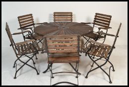 A 20th Century circular teak topped metal framed folding garden table together with a set of six