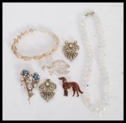 A selection of vintage costume jewellery to include a floral rhinestone brooch, a cold painted dog