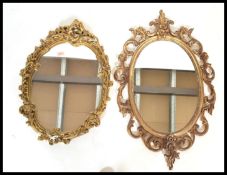 Two antique style 20th Century ornate glass wall mirrors having faux food gilt ormolu scrolled