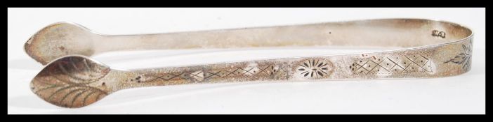 A pair of 19th Century Georgian silver hallmarked sugar tongs having engraved geometric patterning