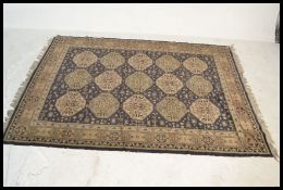 A large 20th century Persian floor carpet Bokhara rug having a blue ground with geometric borders