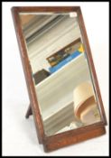 An early 20th Century oak framed freestanding hatmaker's shop milliner mirror having a rectangular
