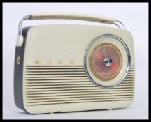 A vintage retro Bush radio having a cream plastic casing and tuning dial to the front, carrying