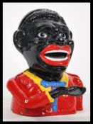 A vintage 20th Century cast iron money bank of a black gentleman having coin slot to mouth and