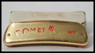 A rare vintage 20th Century M Hohner Comet space age harmonica having a gilt brass body with red