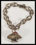 A stamped 800 silver bracelet having decorative links with rope chain detailing with a charm