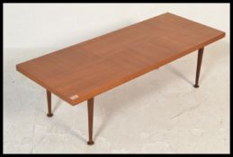 A vintage mid 20th Century teak wood coffee table, the rectangular top raised on shaped tapering