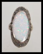 A stamped 925 silver Art Deco style ring having a central opal panel and marcasite accent stones.