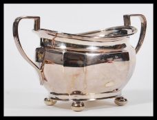 An early 20th Century hallmarked silver sugar bowl by Atkin Brothers raised on four bun feet with