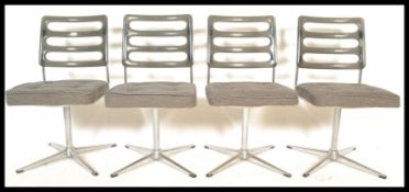A set of four vintage retro 20th Century dining chairs raised on a central tubular column with